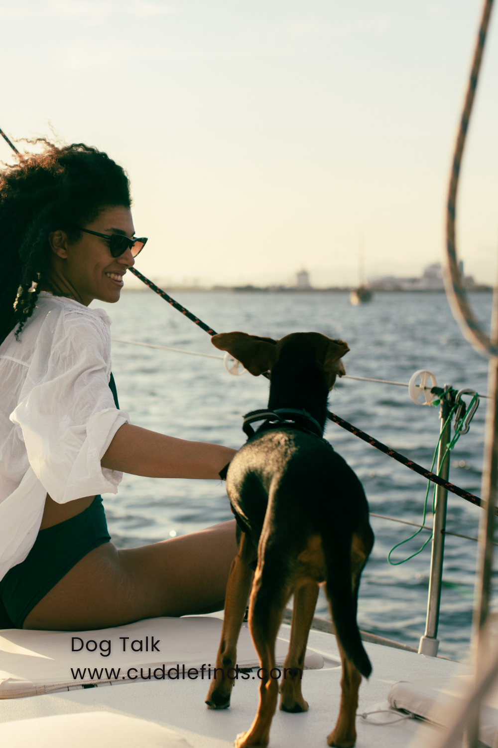 A female dog owner on a boat with her dog.