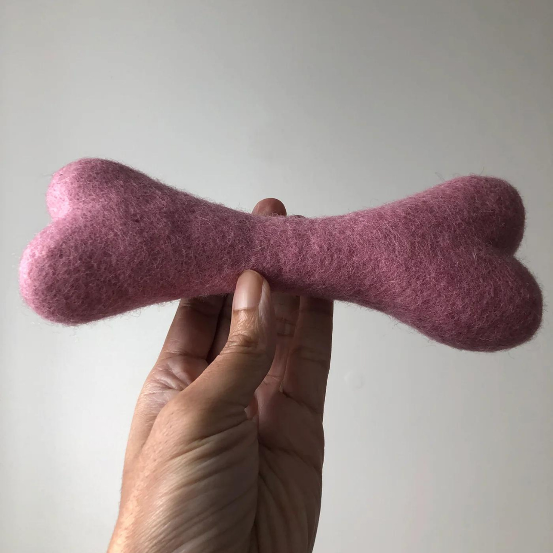 Handmade pink felt wool dog bone toy.